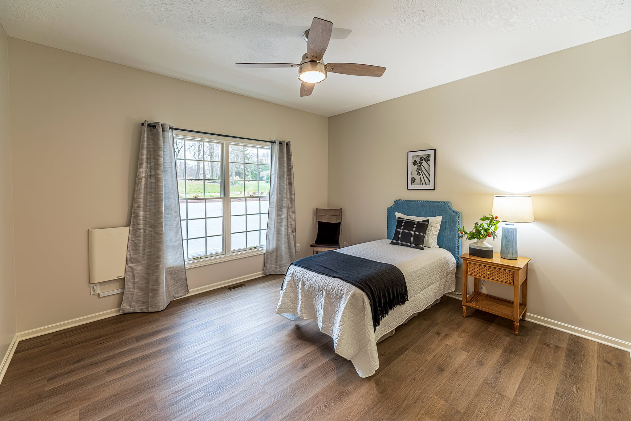 Another inviting bedroom featuring warm colors, abundant natural light, and a bedside table lamp at Camella Living.