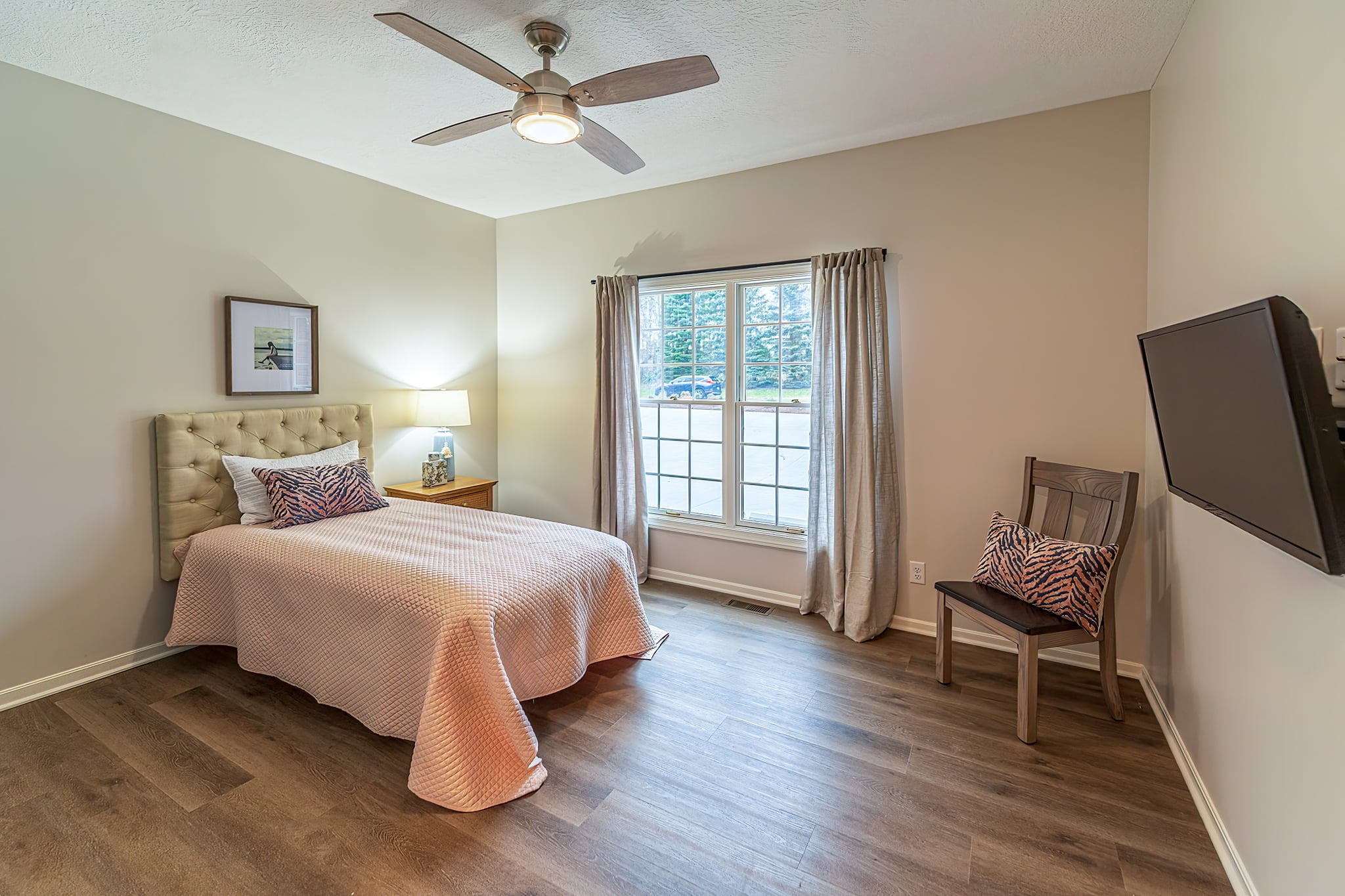 Bright and inviting bedroom with warm colors, abundant natural light, and a bedside table lamp at Camella Living.