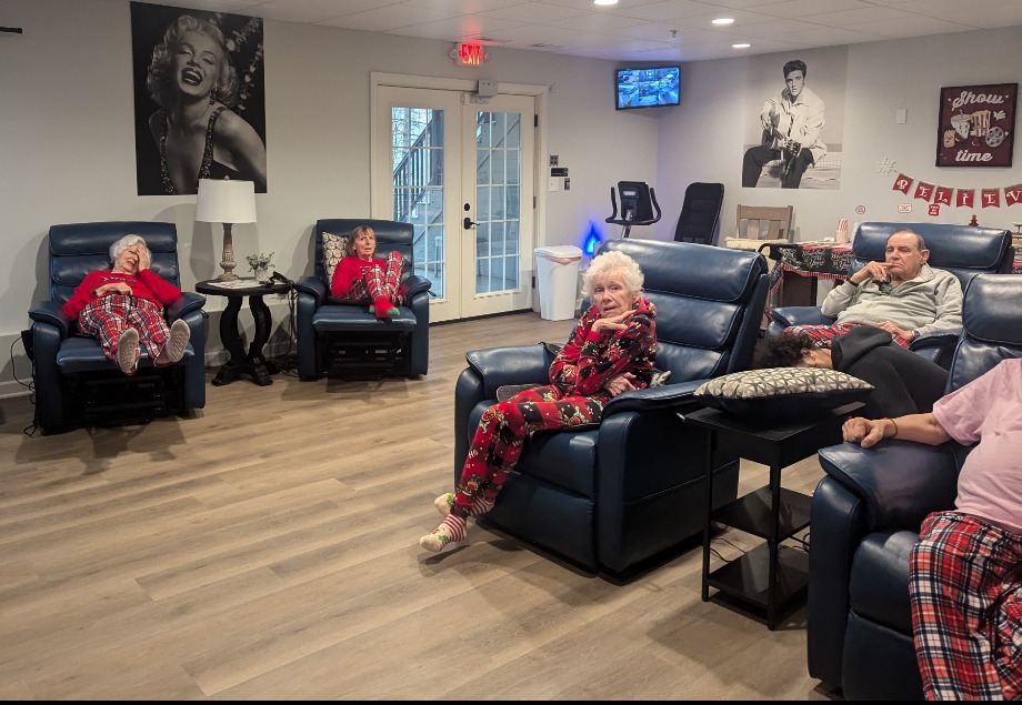 A different angle of the common living and activity area, focusing on open spaces and comfortable seating, with panoramic windows overlooking a wooded area at Camella Living.